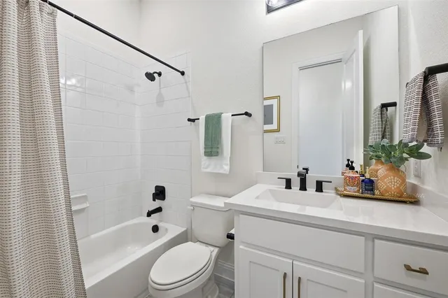 a bathroom with a sink a toilet a tub and shower