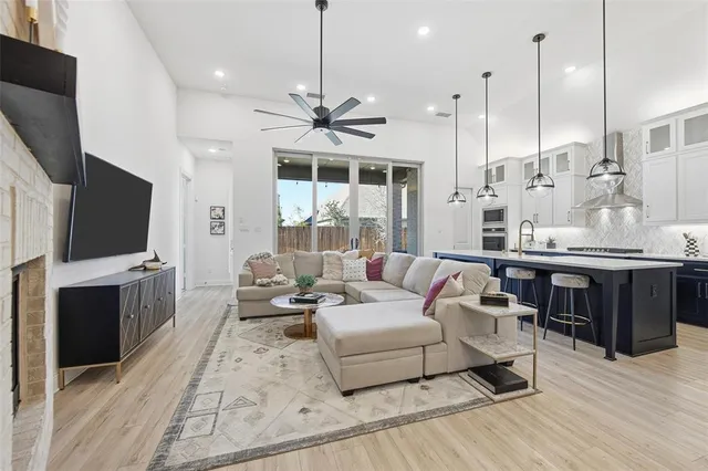 a living room with furniture a flat screen tv and a large window