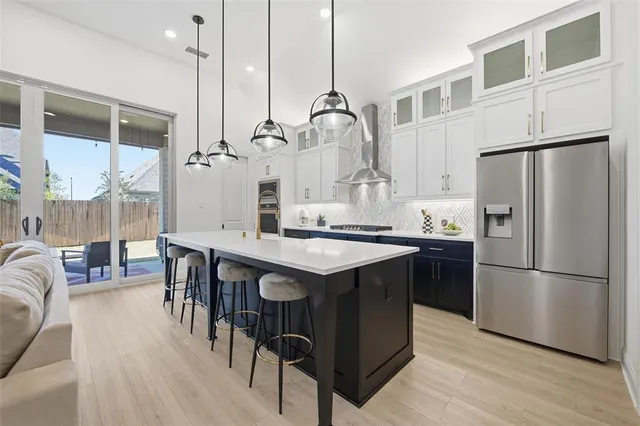 a kitchen with stainless steel appliances granite countertop a table chairs stove and refrigerator