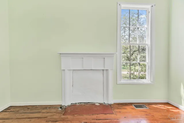 a kitchen with a sink dishwasher a stove and white cabinets with wooden floor