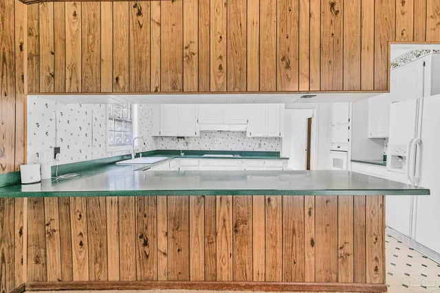 a view of kitchen with white cabinets and a sink
