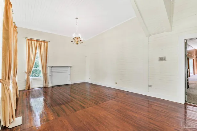 an empty room with wooden floor and a window