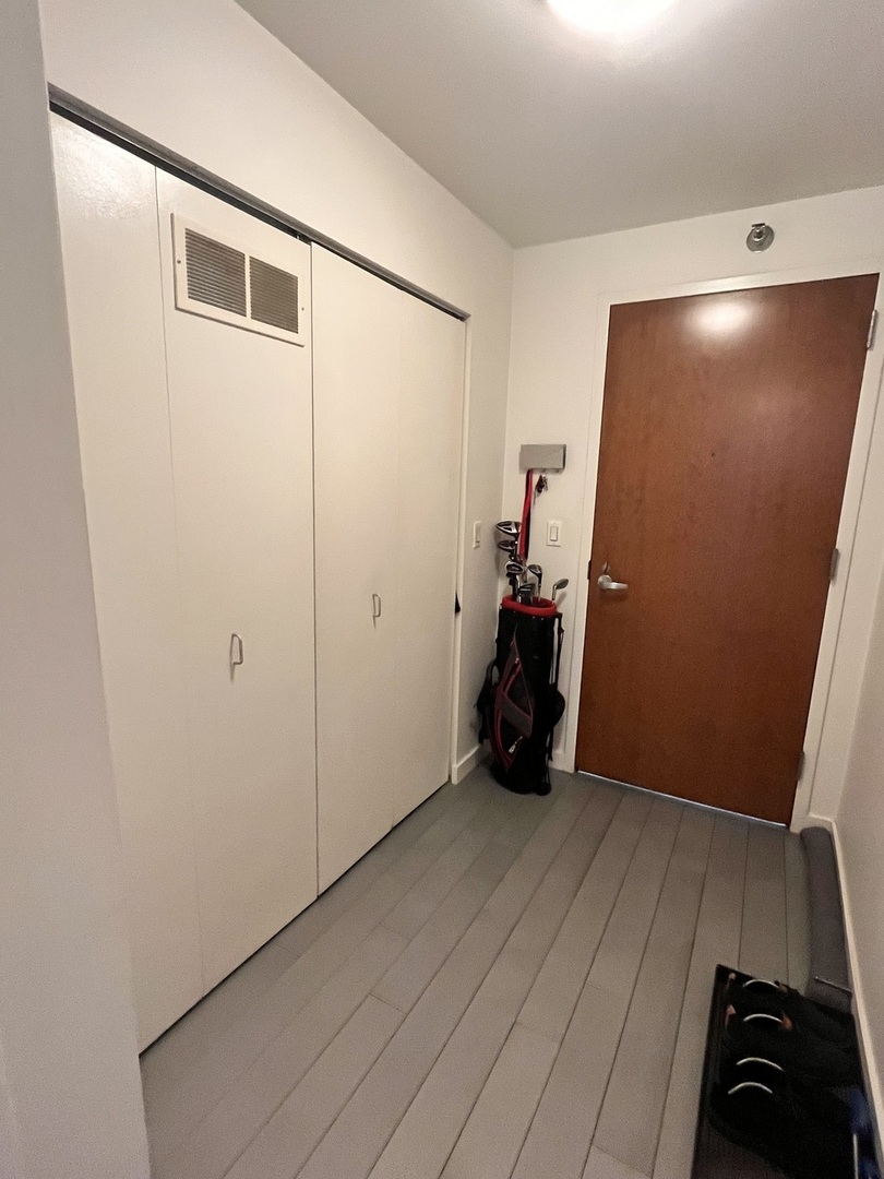 235 West Van Buren Street, Unit 2415 Chicago, IL 60607 - Photo 18 of 19 a view of an empty room with wooden floor and closet