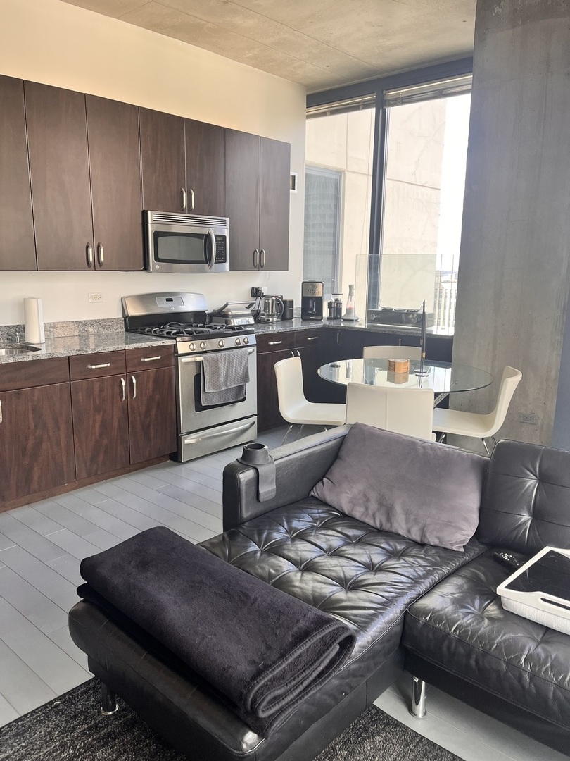 235 West Van Buren Street, Unit 2415 Chicago, IL 60607 - Photo 3 of 19 a living room with furniture and a stove