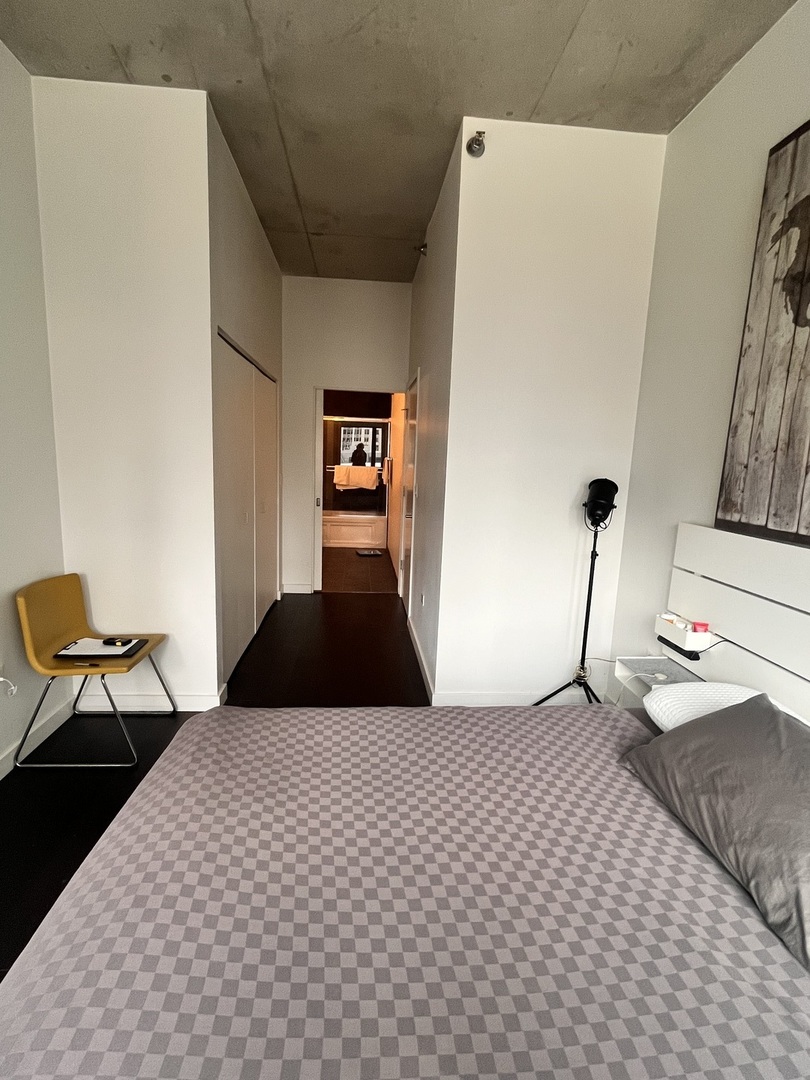 235 West Van Buren Street, Unit 2415 Chicago, IL 60607 - Photo 9 of 19 a bedroom with a bed and chair