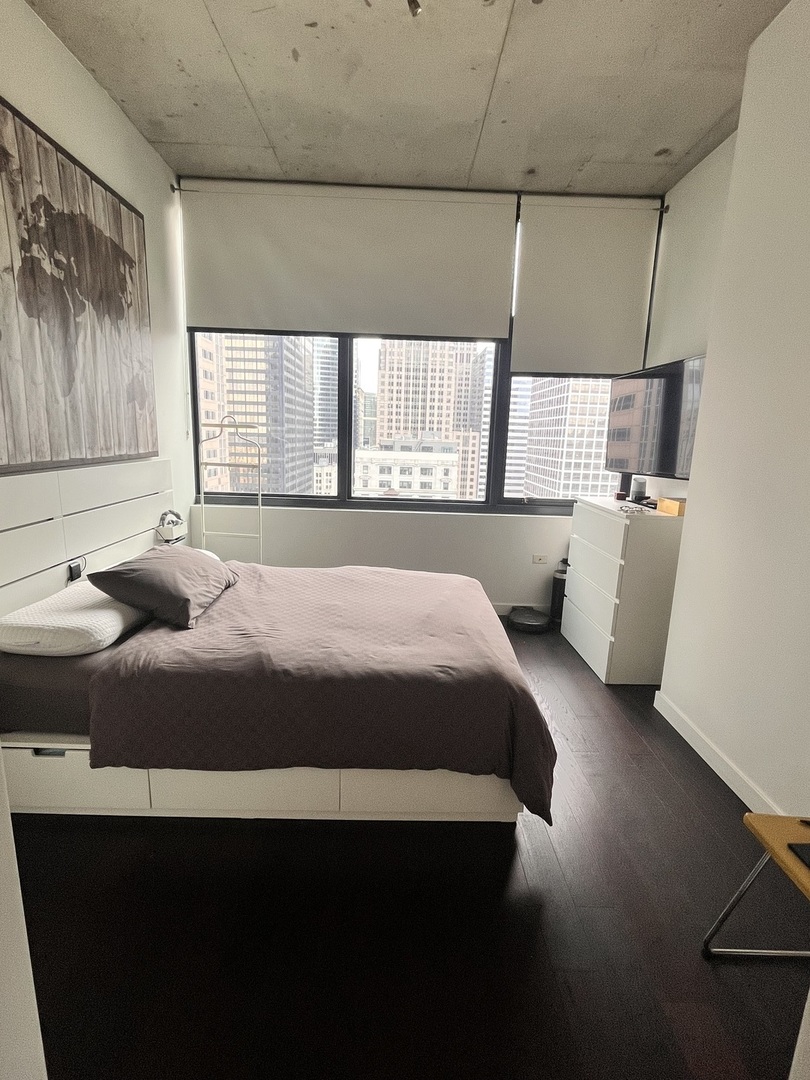 235 West Van Buren Street, Unit 2415 Chicago, IL 60607 - Photo 10 of 19 a bedroom with a bed and window