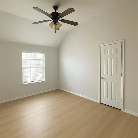 an empty room with a window and a fan