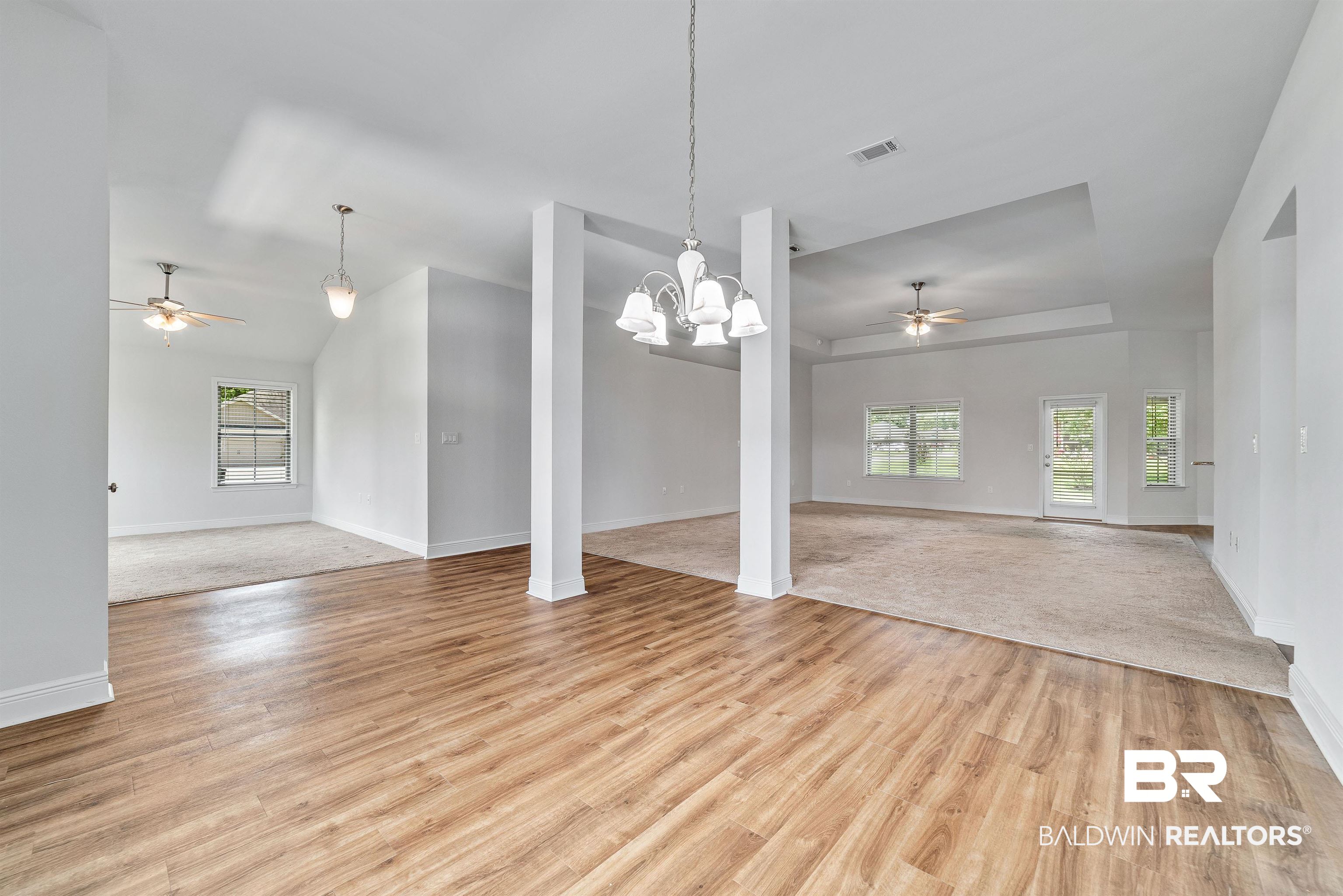 13155 Wishbone Court Foley, AL 36535 - Photo 4 of 39 Carpeted spare room featuring decorative columns, ceiling fan with notable chandelier, and lofted ceiling