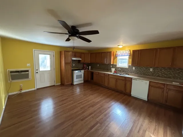 a large kitchen with wooden floors and stainless steel appliances