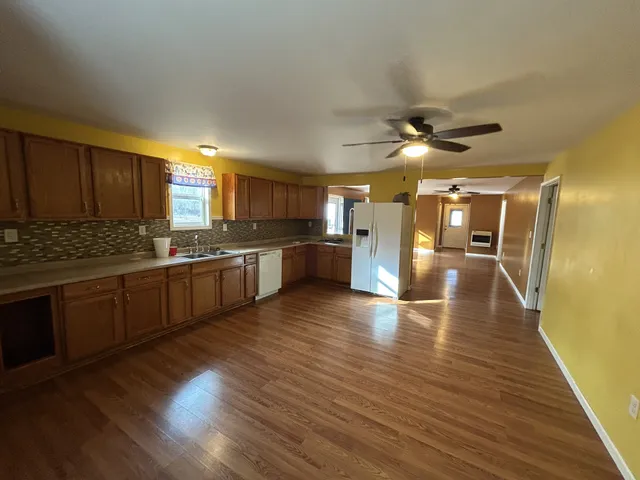 a kitchen with stainless steel appliances granite countertop a stove cabinets and wooden floor