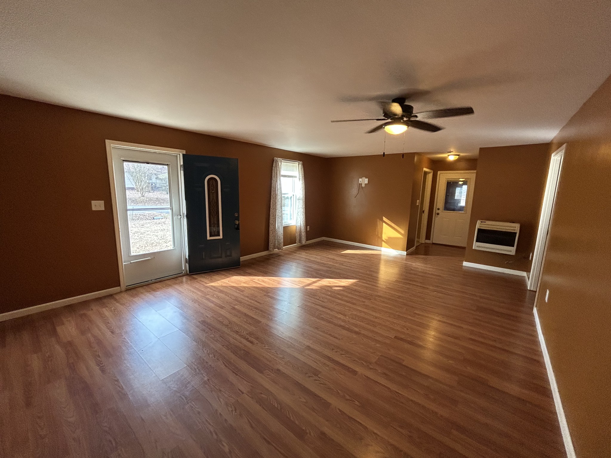 1026 Tom White Road Big Sandy, TN 38221 - Photo 7 of 19 a view of an empty room with window and wooden floor