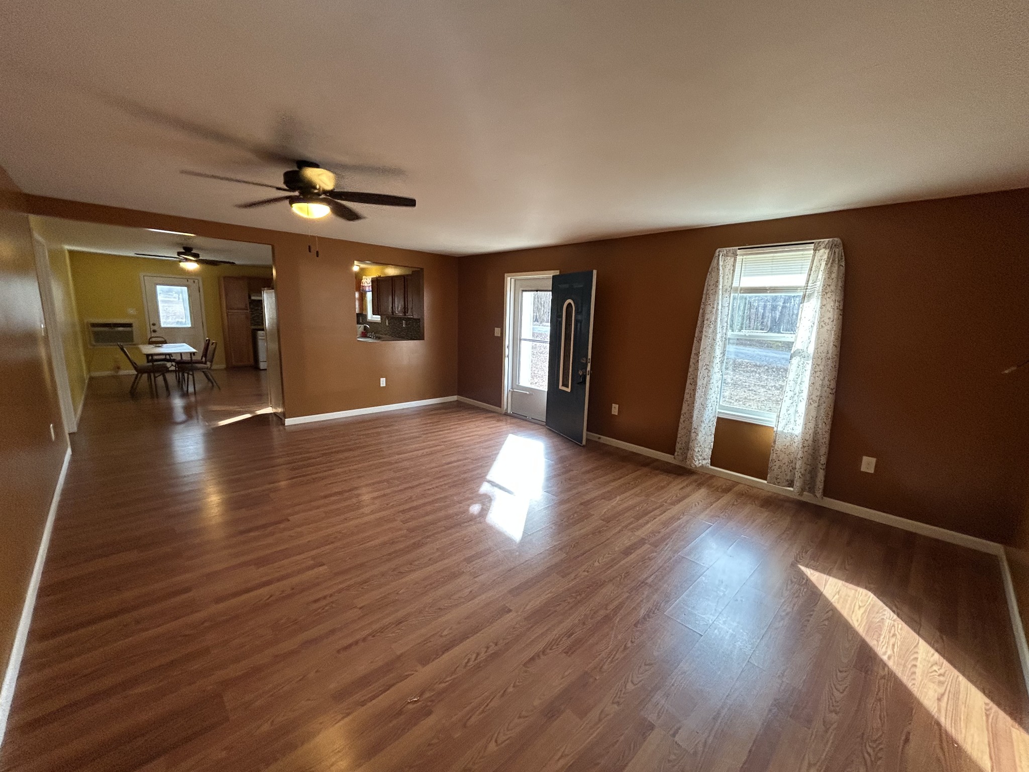 1026 Tom White Road Big Sandy, TN 38221 - Photo 8 of 19 a view of an empty room with wooden floor and a window