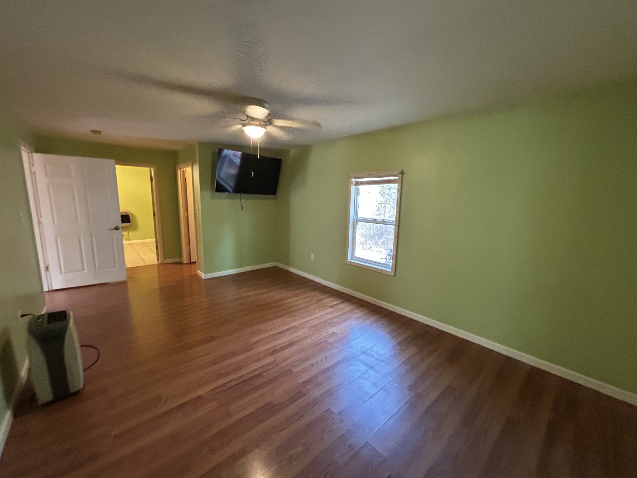 1026 Tom White Road Big Sandy, TN 38221 - Photo 10 of 19 a view of an empty room with wooden floor and a window