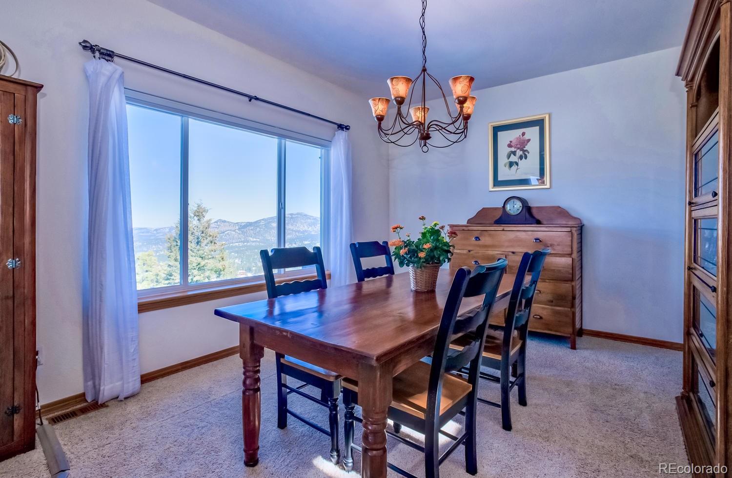 29323 Gray Hawk Drive Evergreen, CO 80439 - Photo 12 of 31 a view of a dining room with furniture window and wooden floor