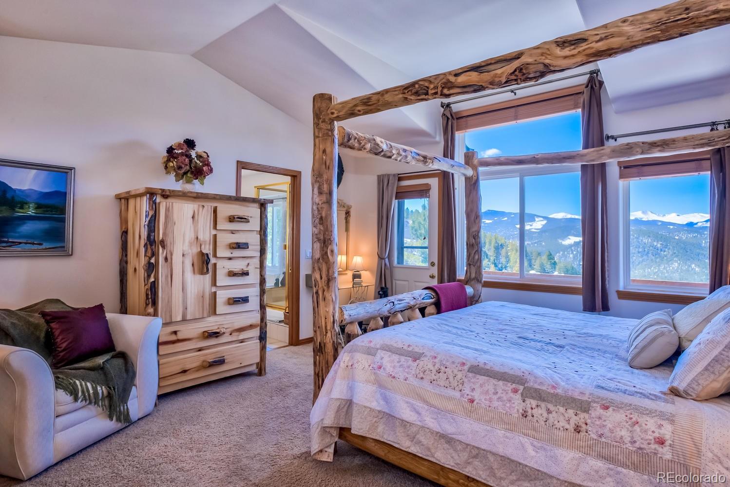 29323 Gray Hawk Drive Evergreen, CO 80439 - Photo 14 of 31 a spacious bedroom with a bed and walk in closet