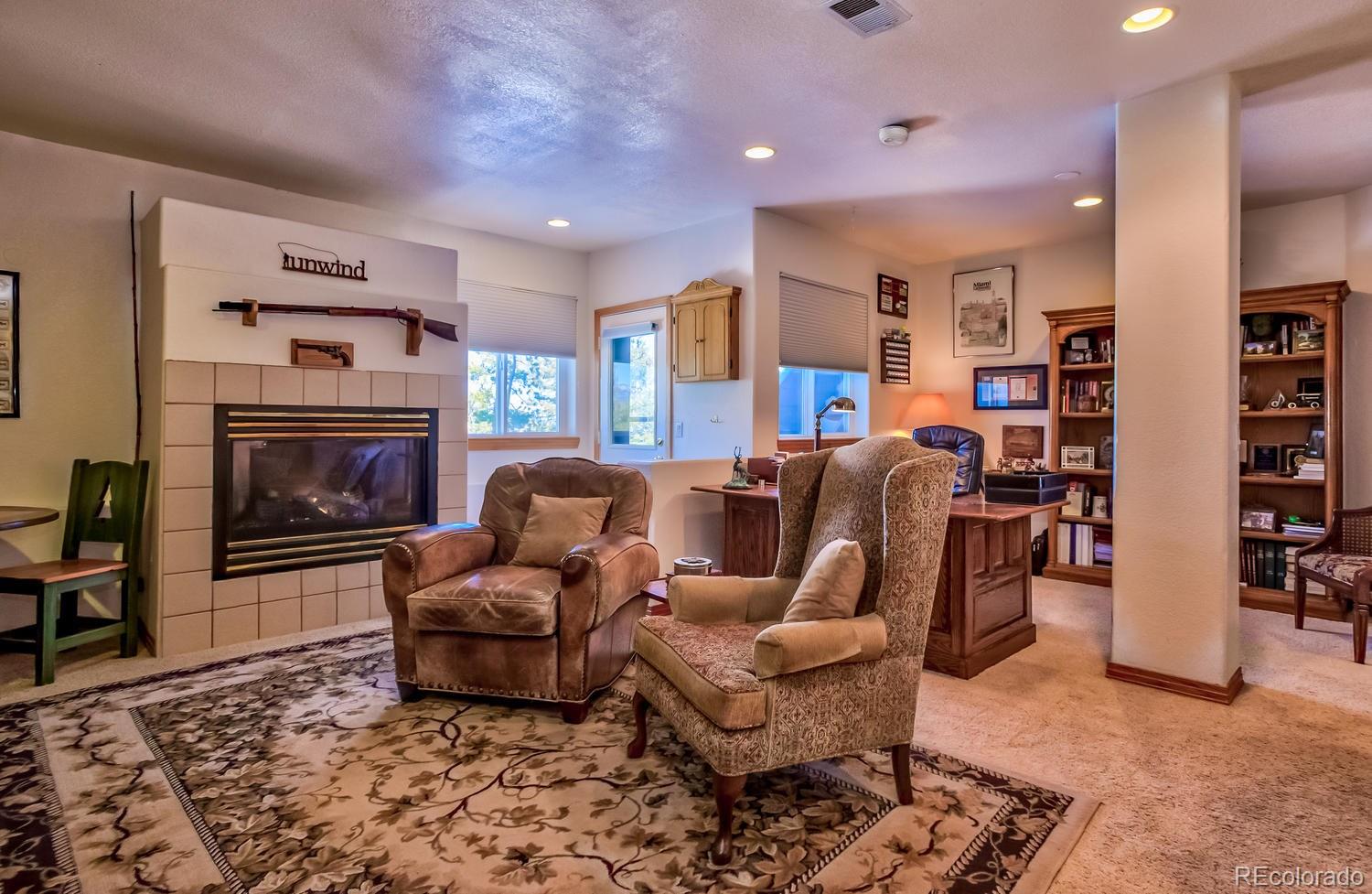 29323 Gray Hawk Drive Evergreen, CO 80439 - Photo 20 of 31 a living room with furniture or couch and a fireplace