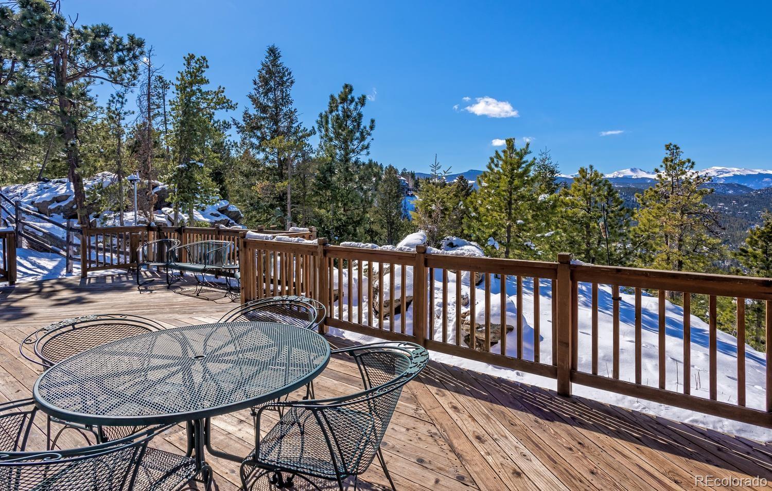 29323 Gray Hawk Drive Evergreen, CO 80439 - Photo 2 of 31 a balcony with table and chairs