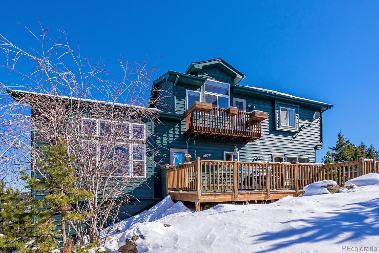 29323 Gray Hawk Drive Evergreen, CO 80439 - Photo 29 of 31 a view of a house with wooden deck and furniture