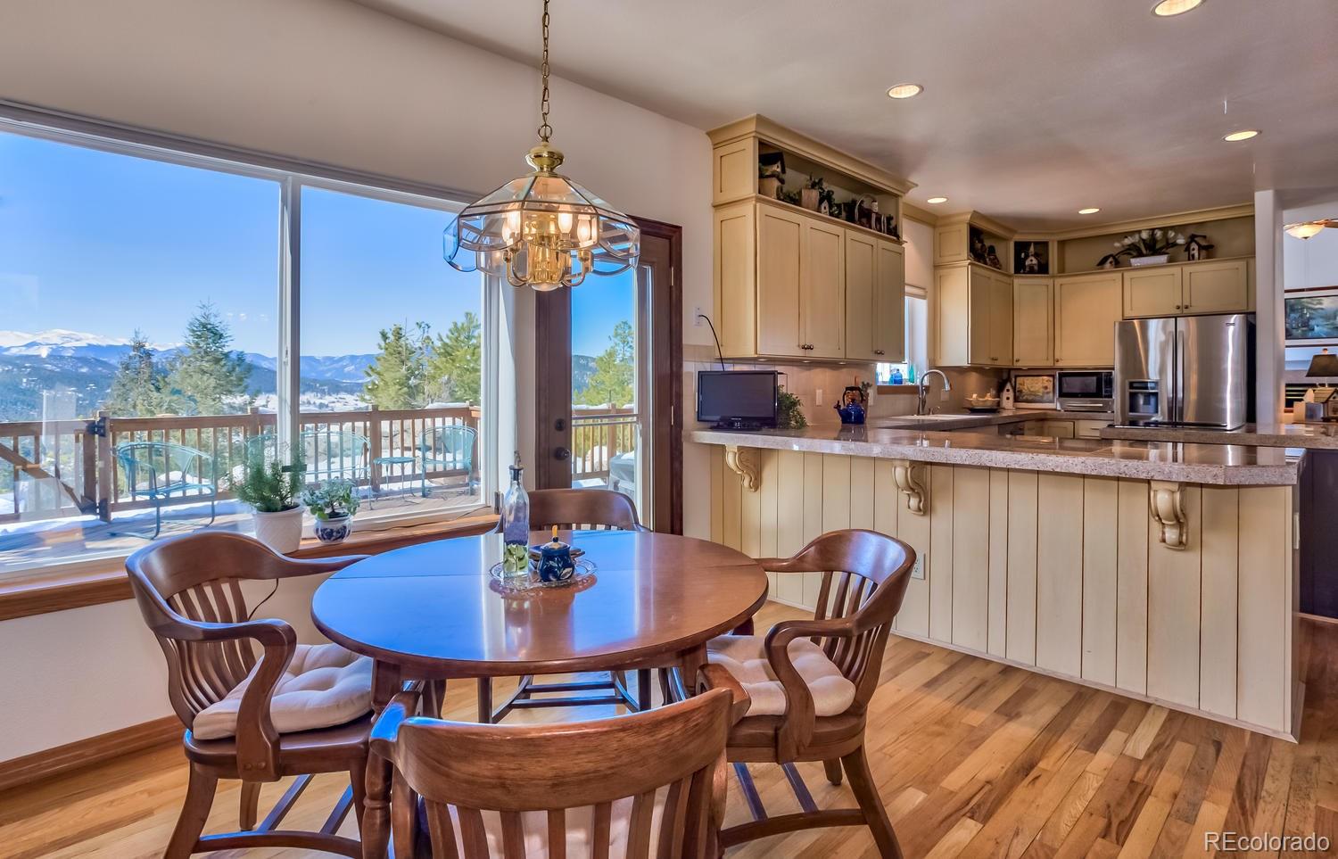29323 Gray Hawk Drive Evergreen, CO 80439 - Photo 5 of 31 a dining room with furniture a chandelier and wooden floor