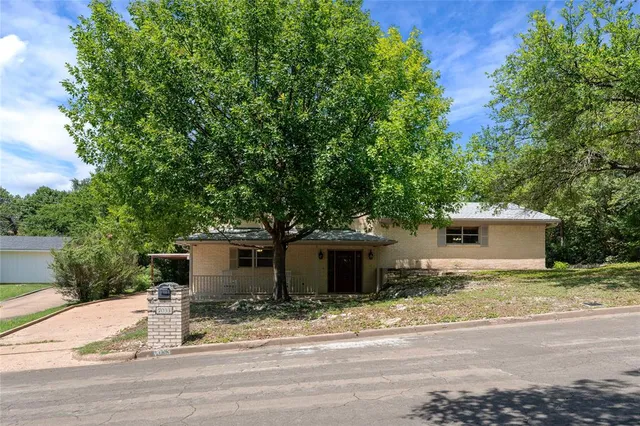 a white house that has a tree in front of it