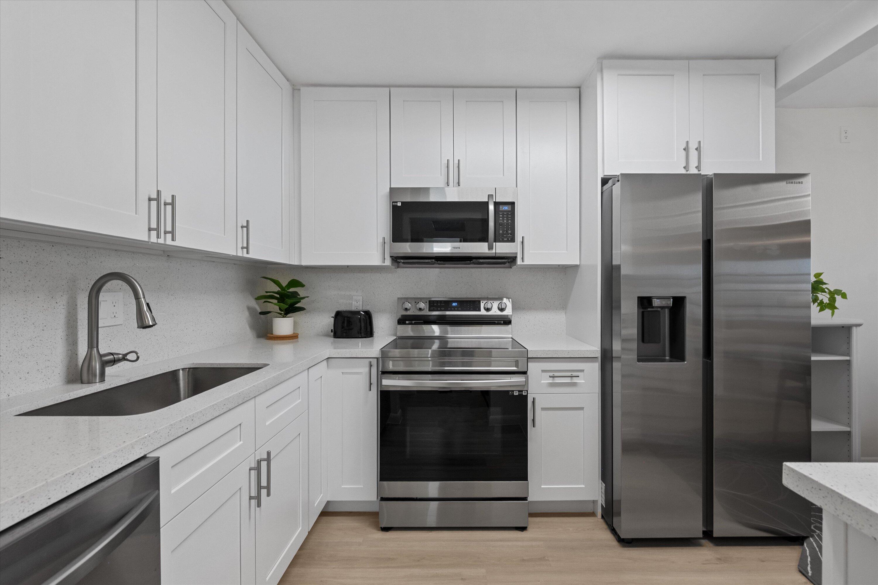 9273 Southwest 8th Street, Unit 416 Boca Raton, FL 33428 - Photo 3 of 19 a kitchen with stainless steel appliances granite countertop a refrigerator stove and sink