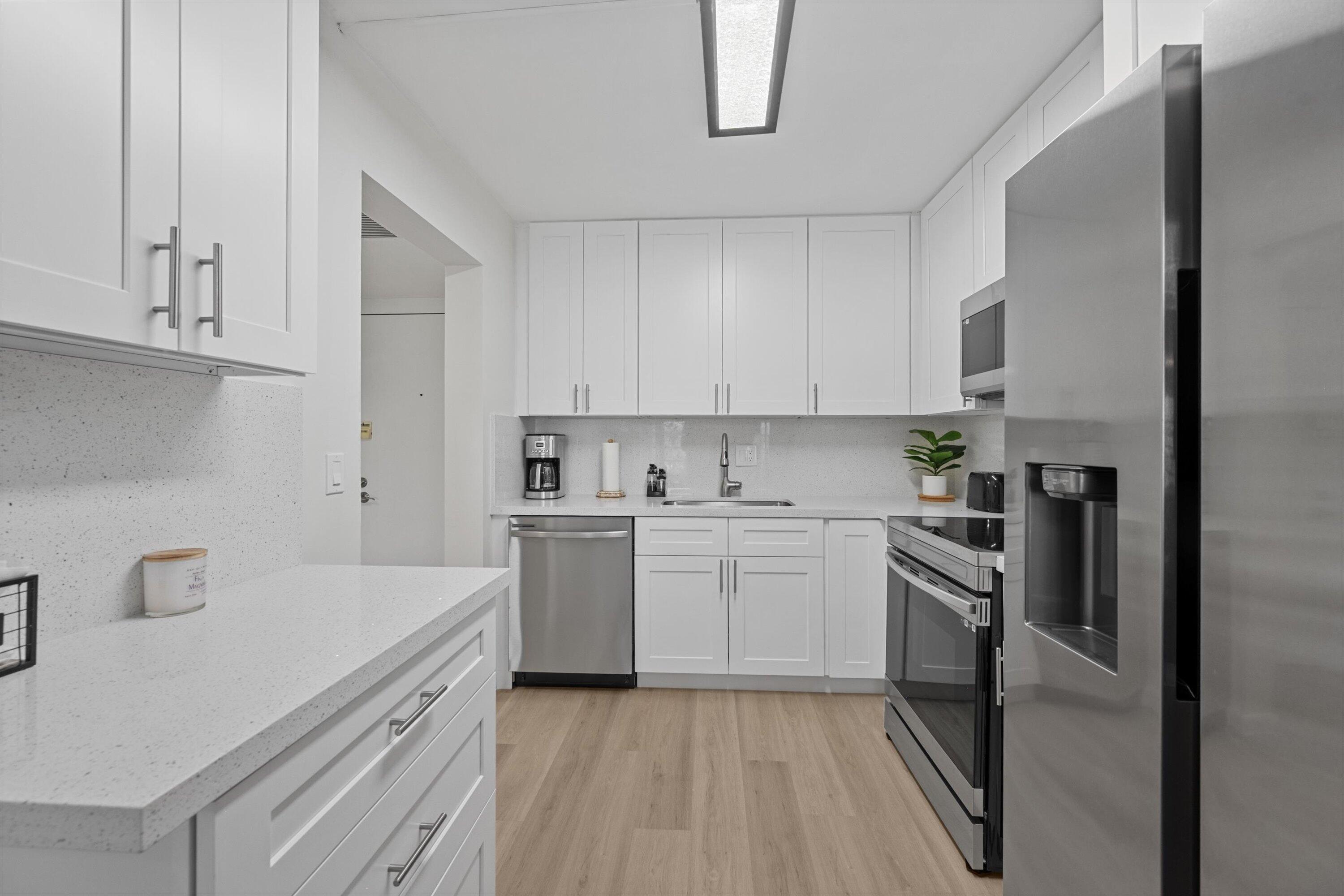 9273 Southwest 8th Street, Unit 416 Boca Raton, FL 33428 - Photo 4 of 19 a kitchen with a sink stove and refrigerator