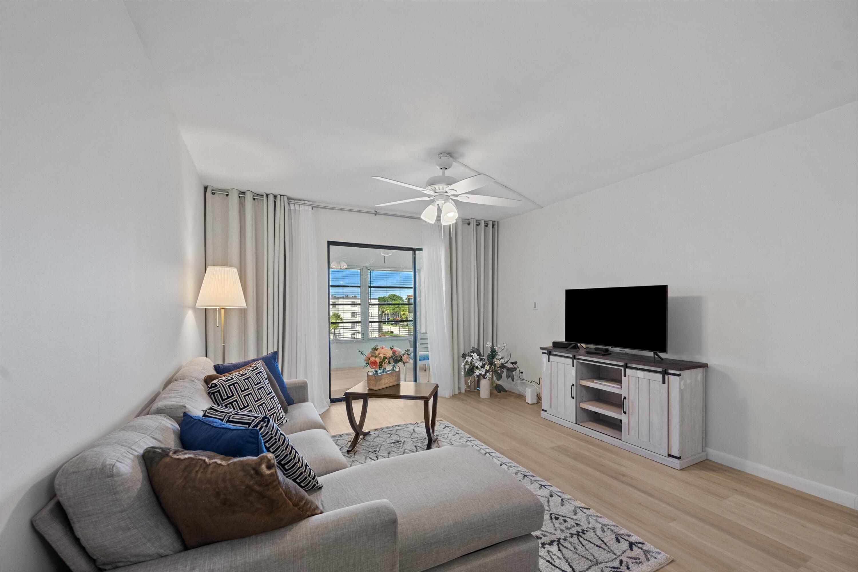 9273 Southwest 8th Street, Unit 416 Boca Raton, FL 33428 - Photo 9 of 19 a living room with furniture and a flat screen tv