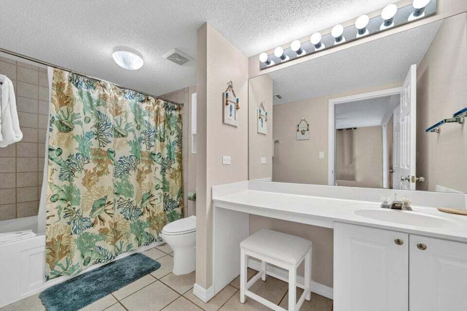 520 Santa Rosa Boulevard, Unit 217 Fort Walton Beach, FL 32548 - Photo 12 of 26 a spacious bathroom with a sink a toilet a mirror a vanity and shower
