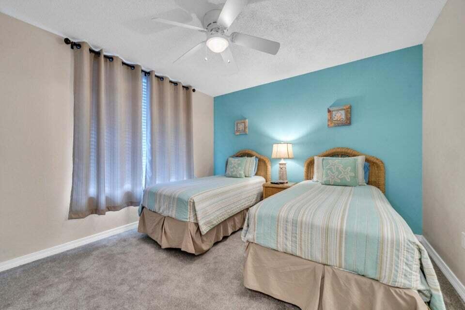 520 Santa Rosa Boulevard, Unit 217 Fort Walton Beach, FL 32548 - Photo 13 of 26 a bedroom with two beds and a chandelier