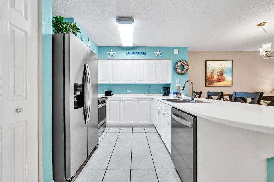 520 Santa Rosa Boulevard, Unit 217 Fort Walton Beach, FL 32548 - Photo 6 of 26 a kitchen with stainless steel appliances a refrigerator sink and cabinets