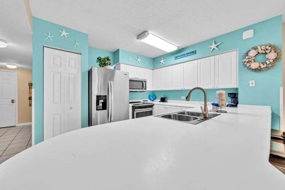 520 Santa Rosa Boulevard, Unit 217 Fort Walton Beach, FL 32548 - Photo 7 of 26 a large white kitchen with a refrigerator a stove a microwave and cabinets