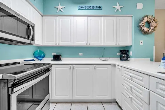 a kitchen with white cabinets and white appliances