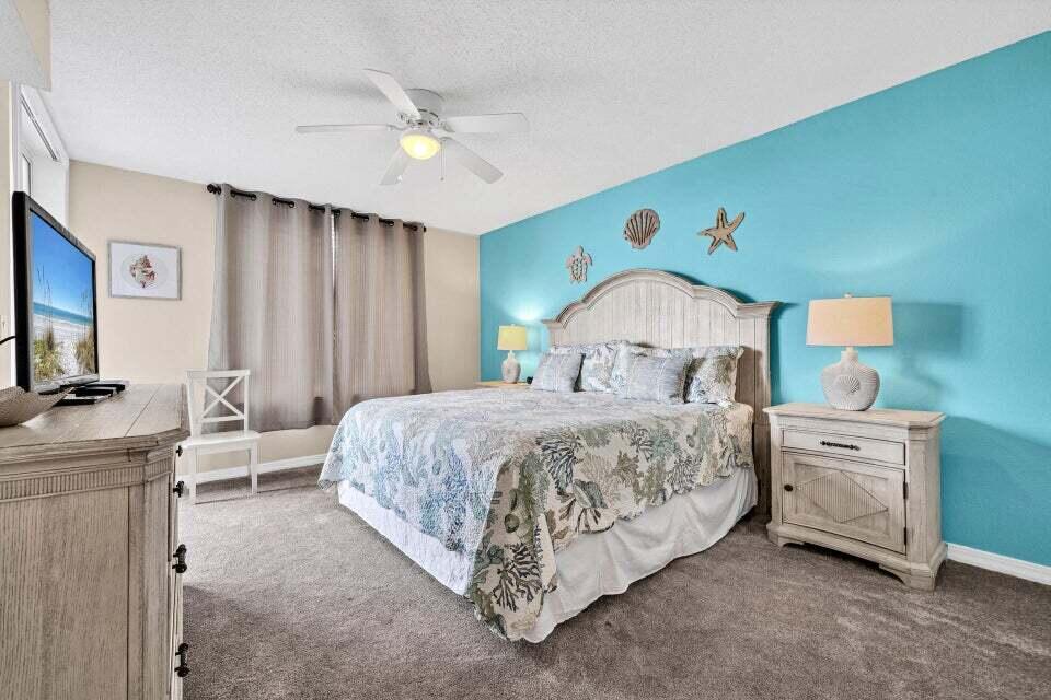 520 Santa Rosa Boulevard, Unit 217 Fort Walton Beach, FL 32548 - Photo 10 of 26 a spacious bedroom with a bed and a flat screen tv