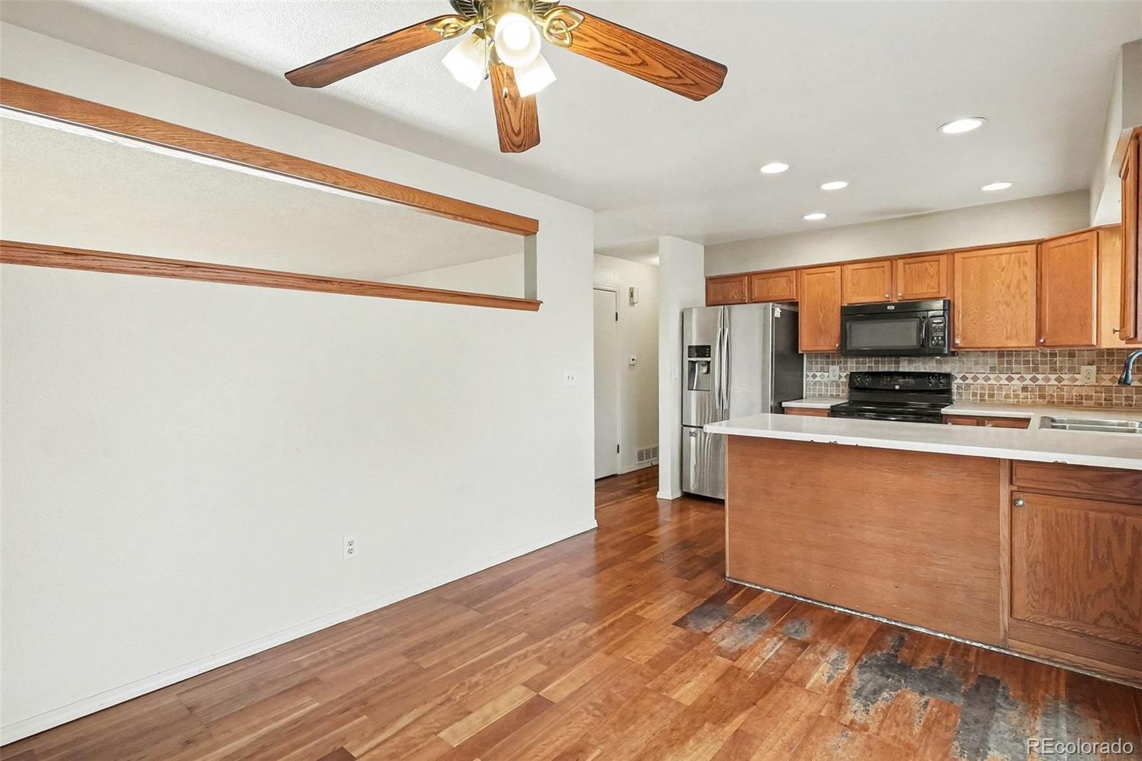 4105 South Laredo Way Aurora, CO 80013 - Photo 3 of 11 a view of kitchen with stainless steel appliances granite countertop cabinets and wooden floor