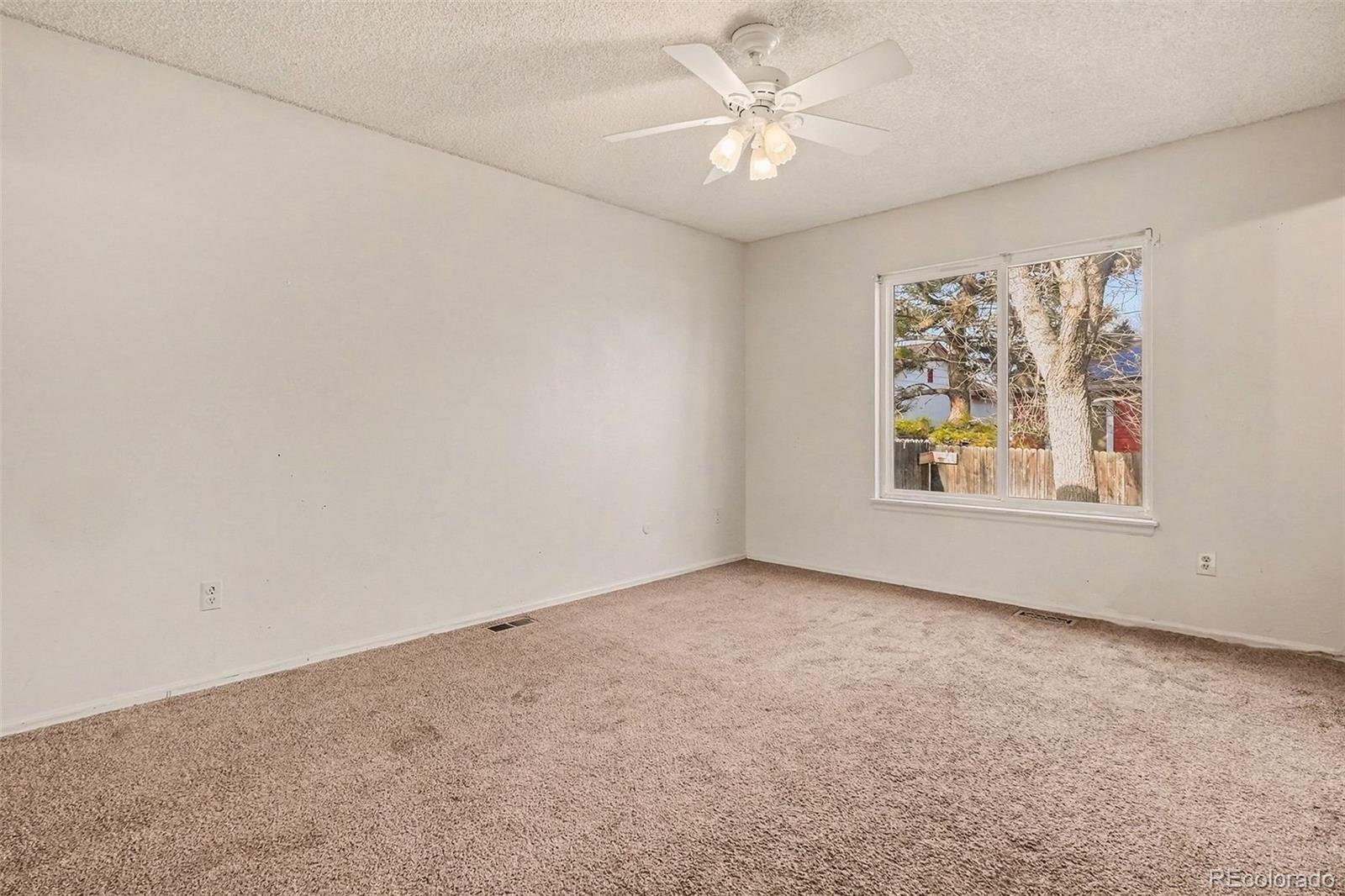 4105 South Laredo Way Aurora, CO 80013 - Photo 5 of 11 an empty room with windows and fan