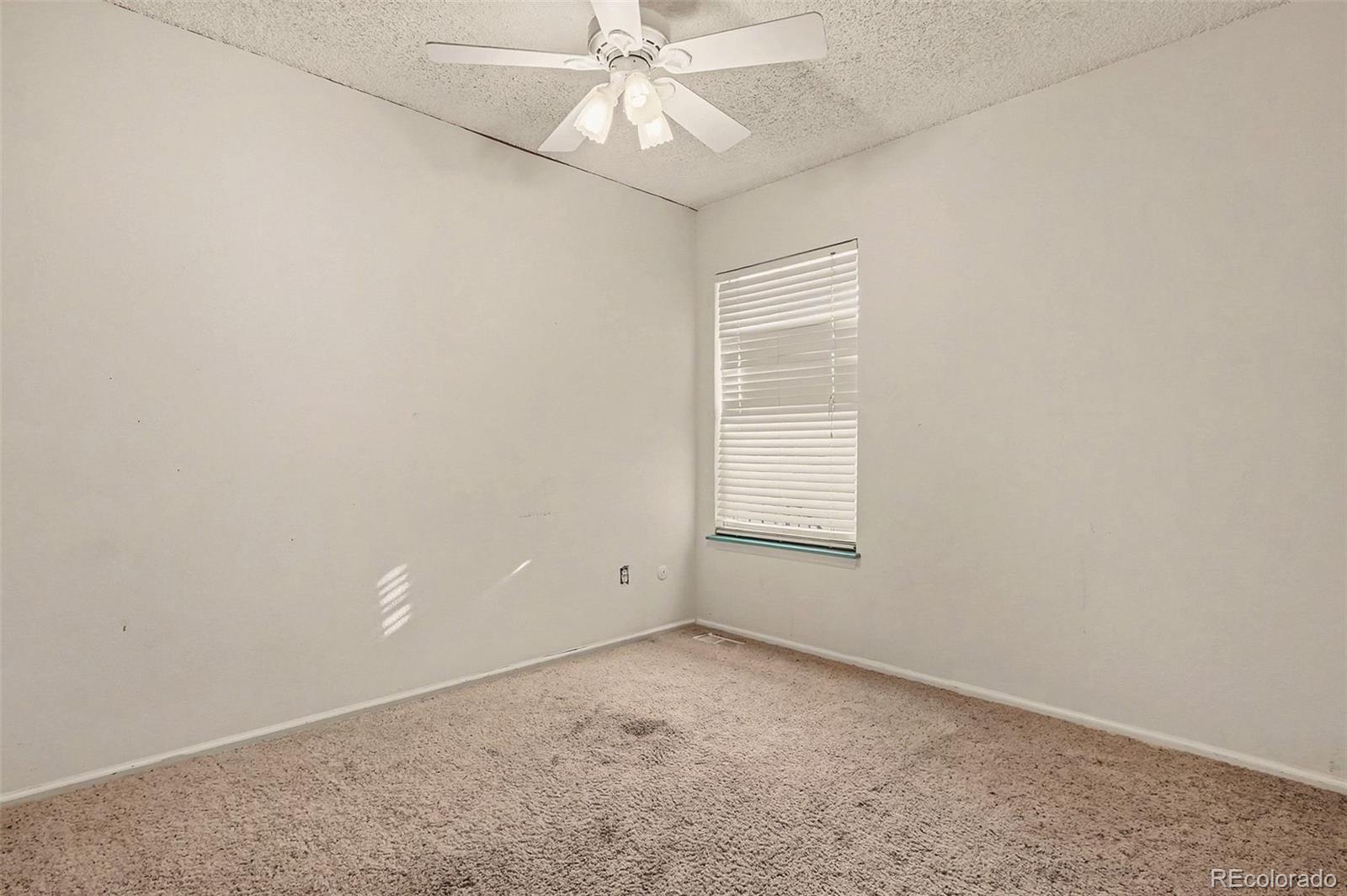 4105 South Laredo Way Aurora, CO 80013 - Photo 7 of 11 an empty room with a window and a ceiling fan