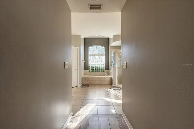 a bathroom with a tub sink and mirror