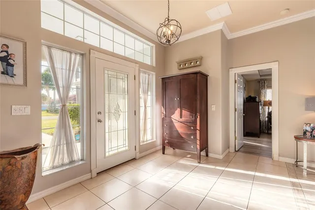 a living room with furniture a dining table and a chandelier