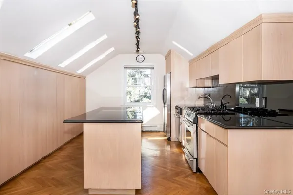 a kitchen with stainless steel appliances kitchen island granite countertop a stove a sink and a microwave