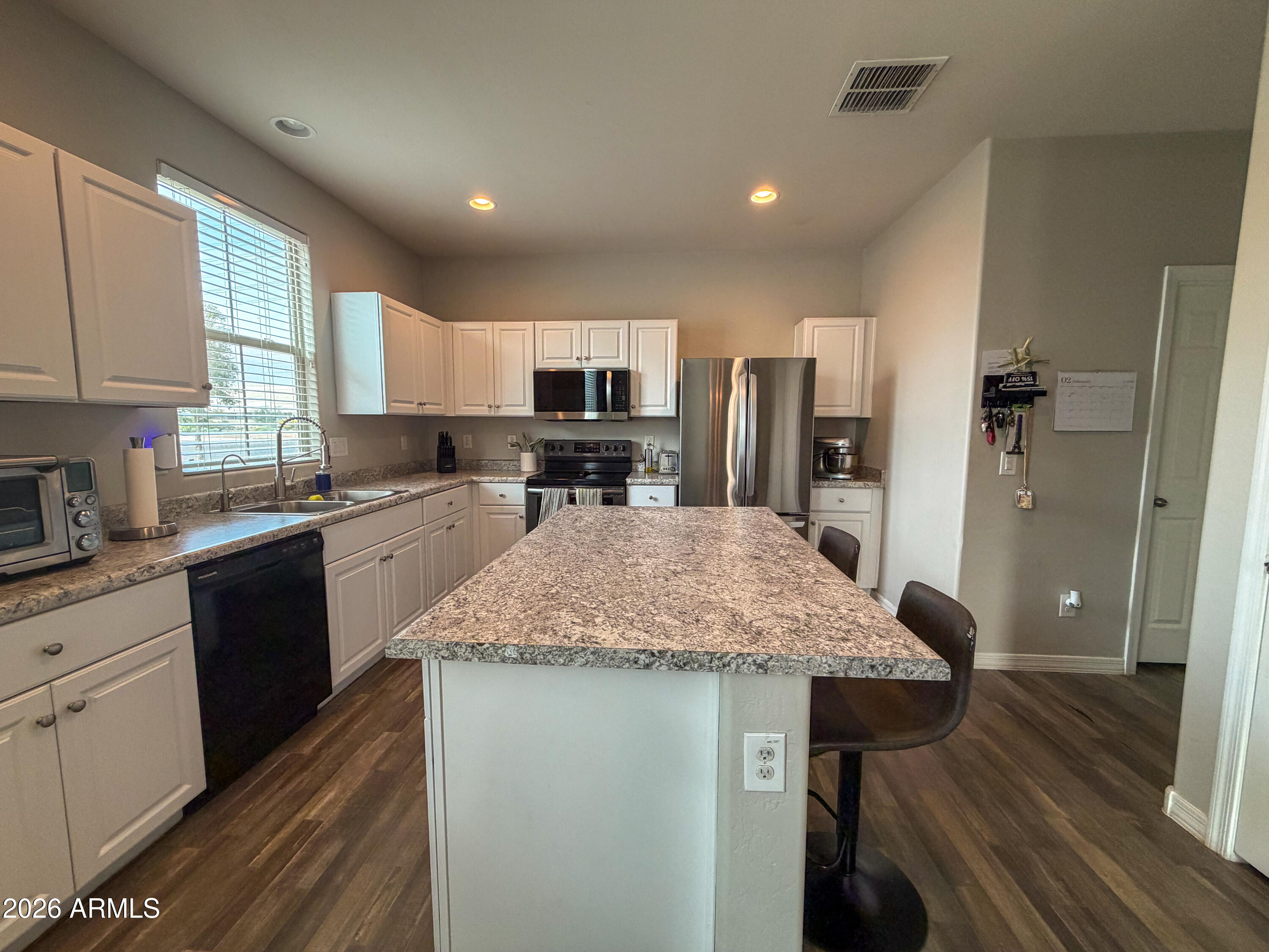 5480 Fulton Street Phoenix, AZ 85043 - Photo 13 of 63 a kitchen with kitchen island granite countertop wooden cabinets a sink dishwasher a stove and a refrigerator