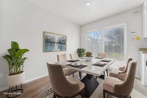 a dining room with furniture potted plants and wooden floor