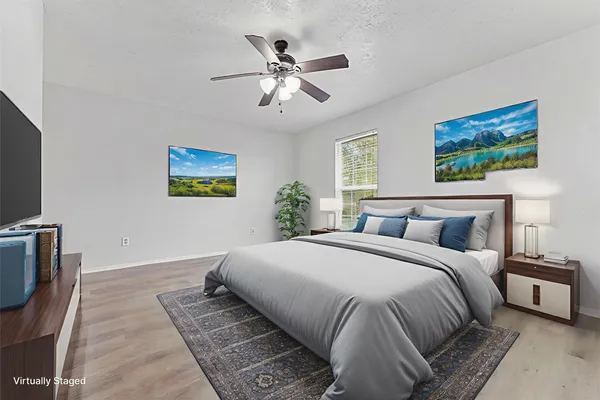 a bedroom with a large bed and a chandelier