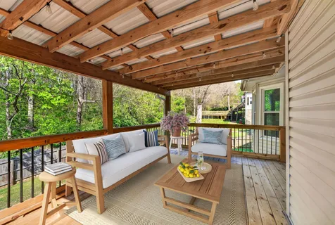 a view of a house with a yard and large tree