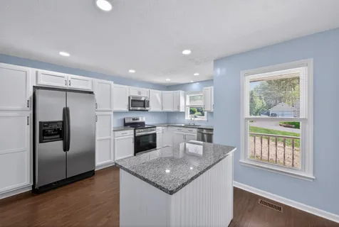 a kitchen with cabinets stainless steel appliances a sink and a counter space