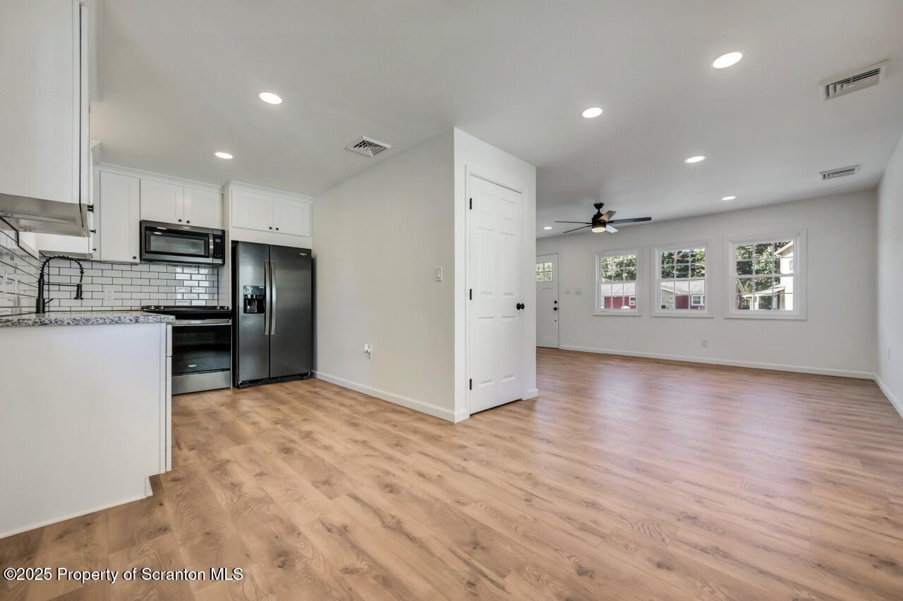 110 Morgan Street Jessup, PA 18434 - Photo 12 of 45 a view of a kitchen with refrigerator stove and wooden floor