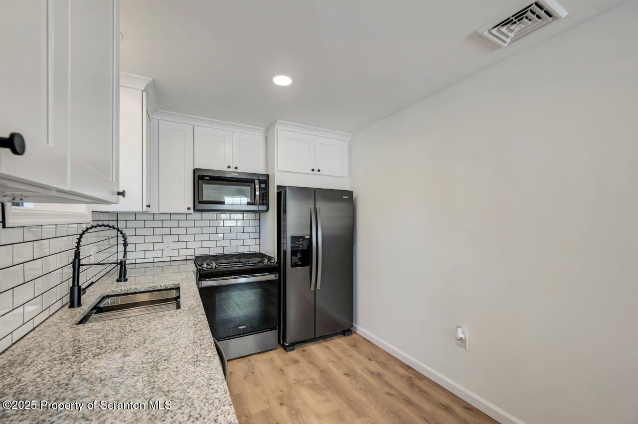 110 Morgan Street Jessup, PA 18434 - Photo 13 of 45 a kitchen with a refrigerator and a stove top oven