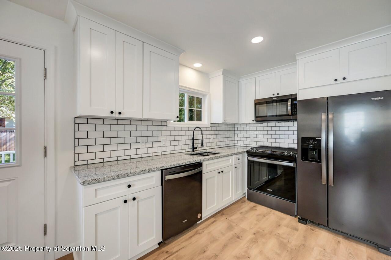 110 Morgan Street Jessup, PA 18434 - Photo 15 of 45 a kitchen with stainless steel appliances granite countertop a sink stove and refrigerator