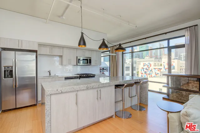 a kitchen with granite countertop a sink a counter space appliances and cabinets