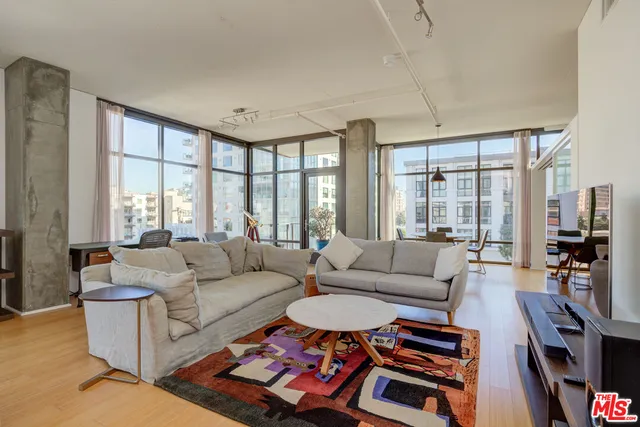 a living room with furniture a flat screen tv and a large window