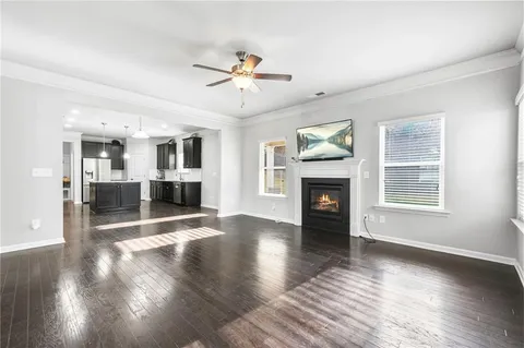 a view of a livingroom with wooden floor a fireplace and windows
